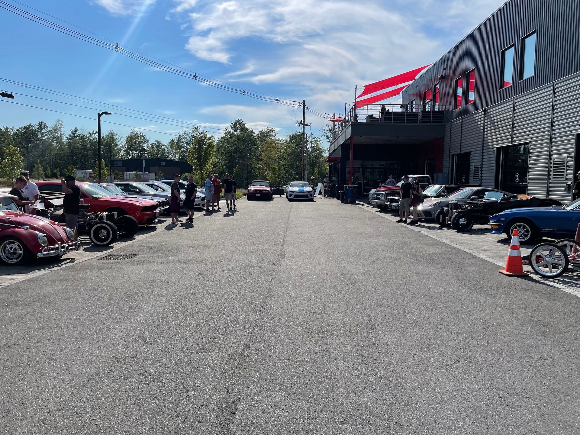 A row of cars are parked on the side of the road in front of a building.