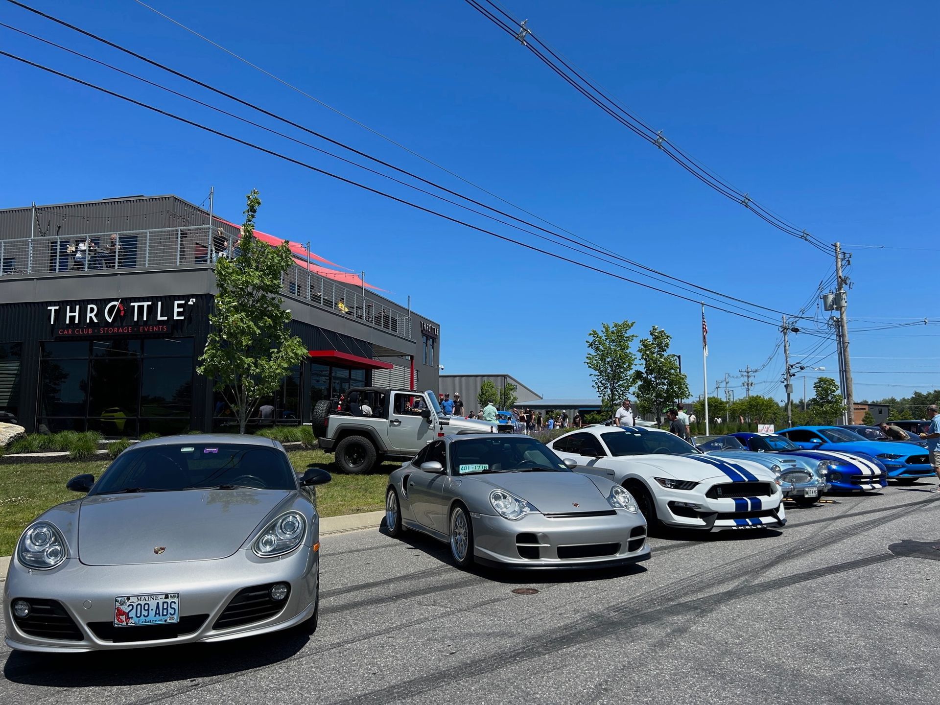 A row of cars are parked on the side of the road in front of a building.