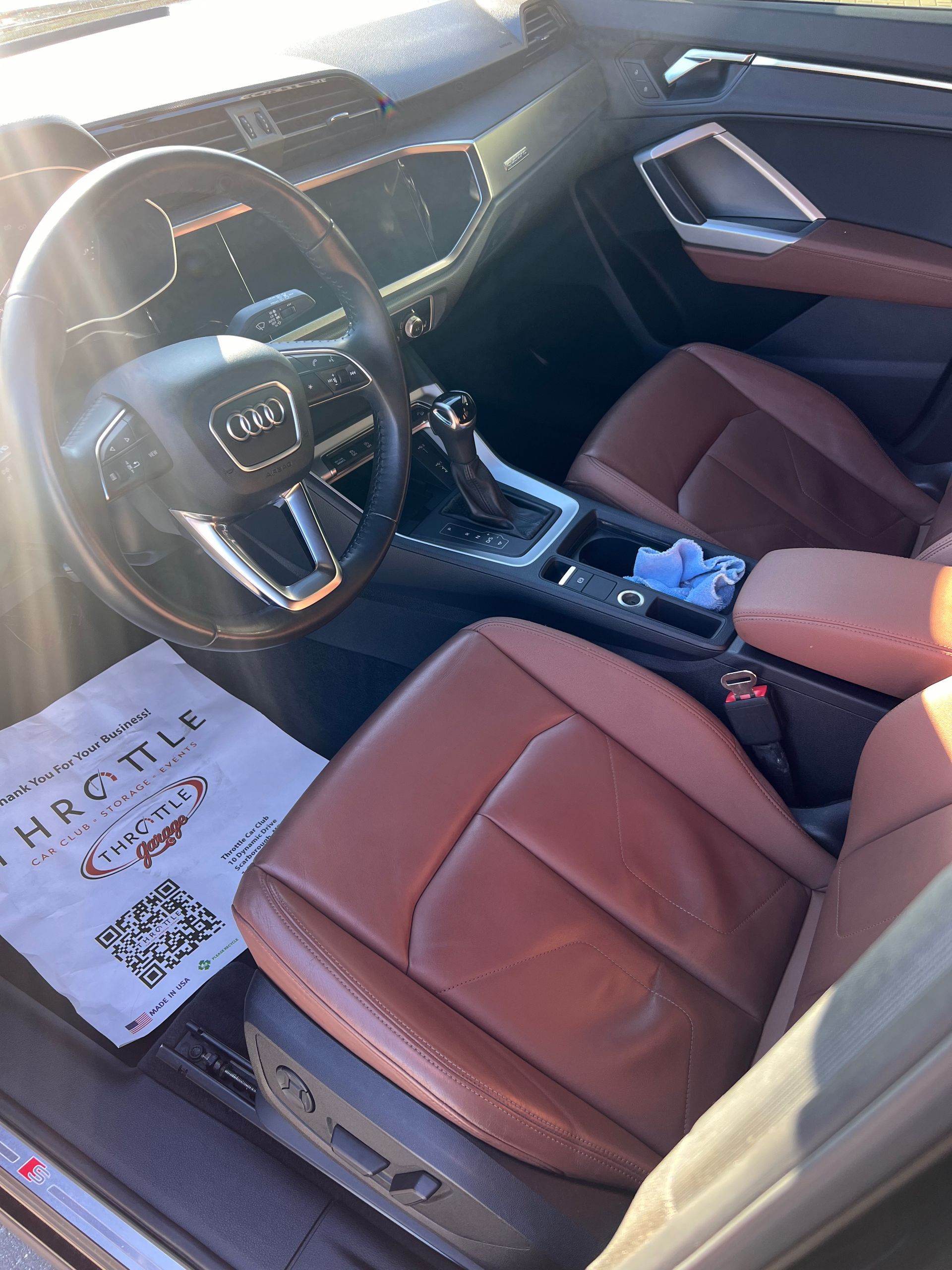 The interior of a car with brown leather seats and a steering wheel.