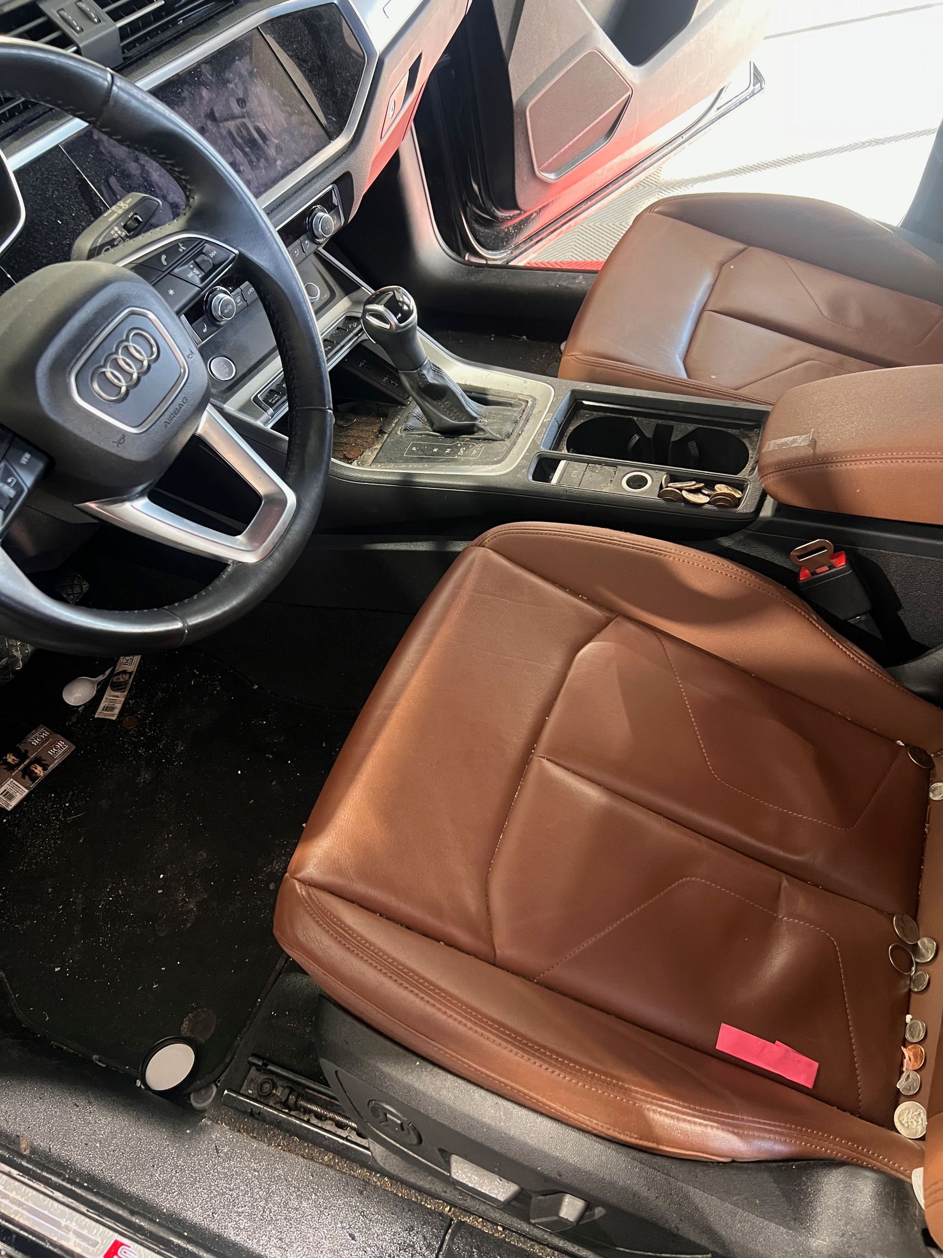 The interior of a car with brown leather seats and a steering wheel.