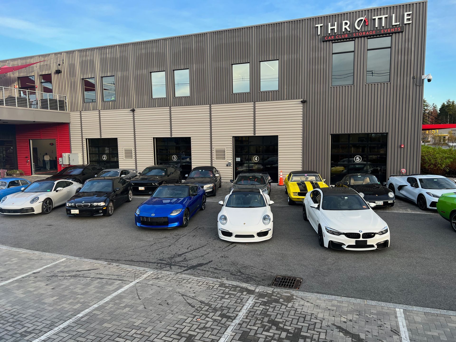 A group of cars are parked in front of a building that says throttle.