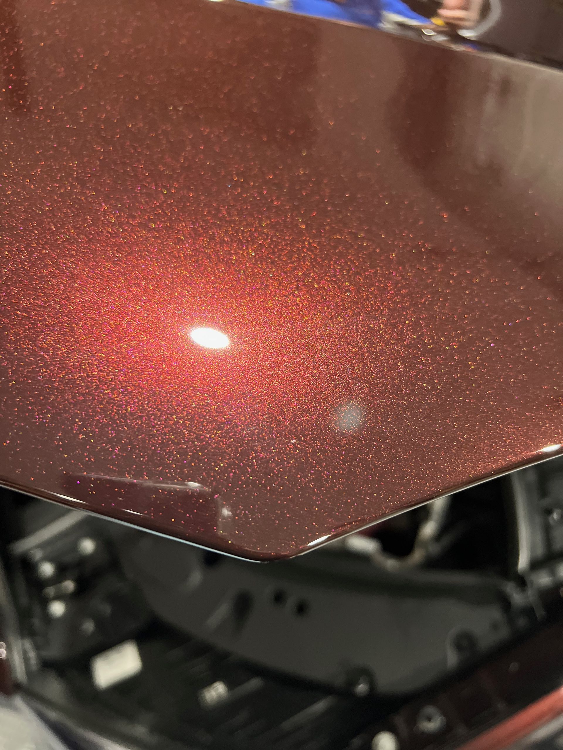 A close up of the hood of a red car