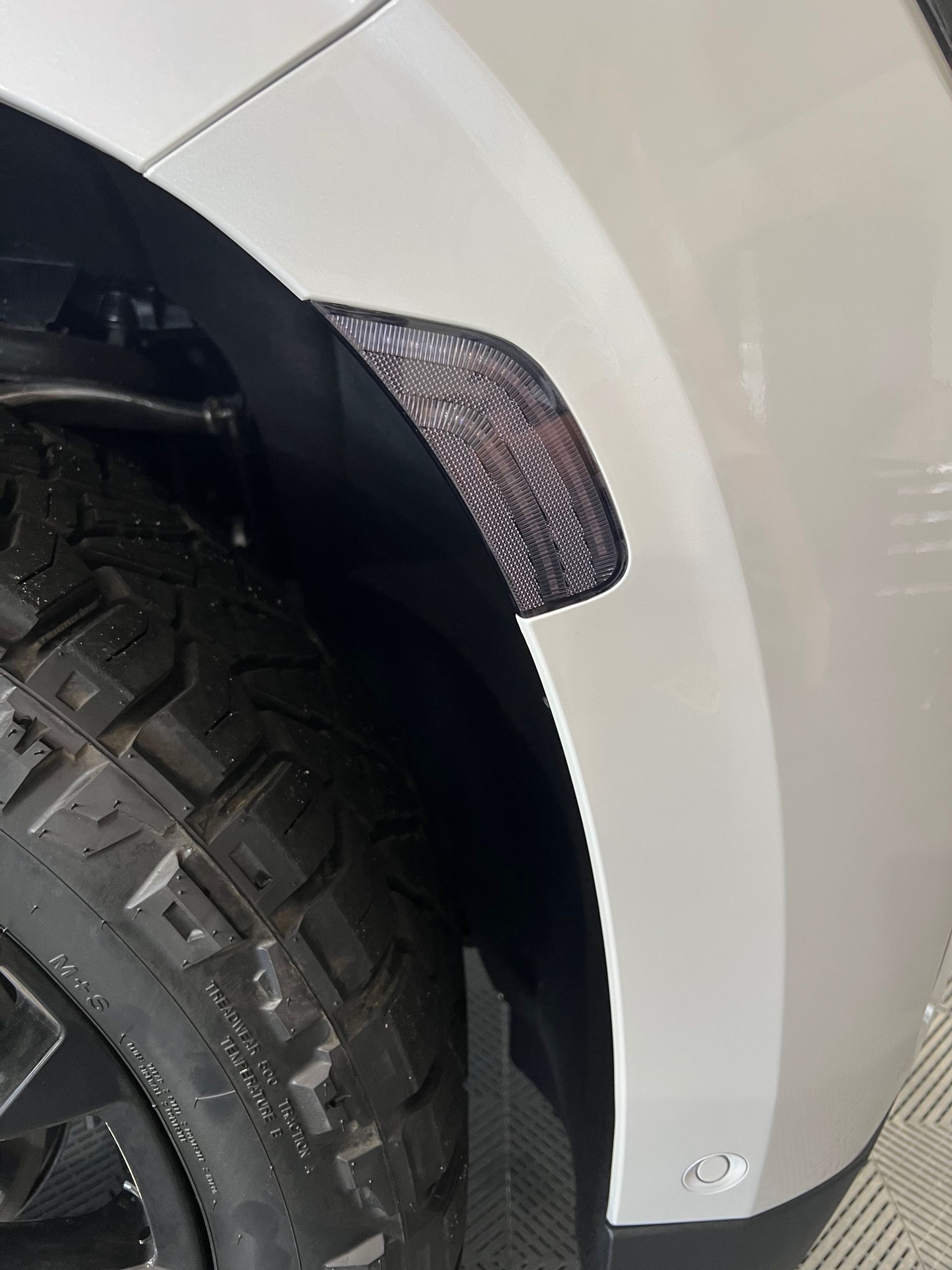 A close up of a car fender with a tire on it.
