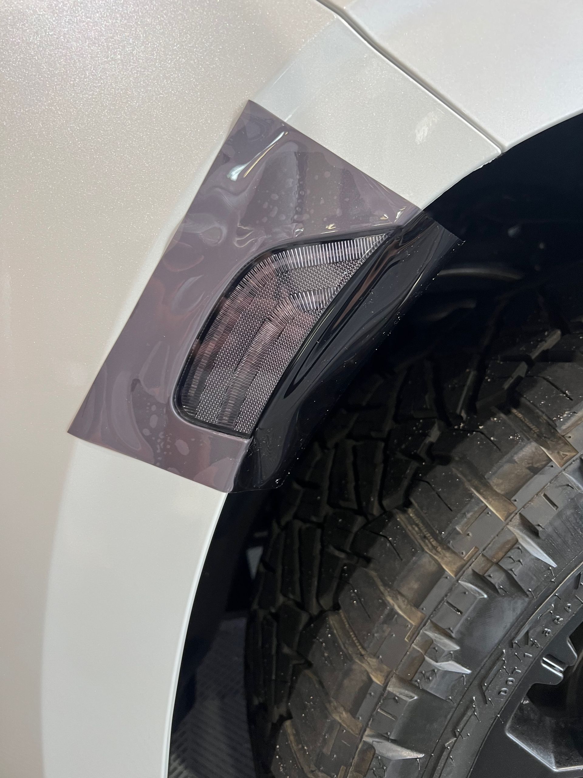 A close up of a car fender with a tire on it.