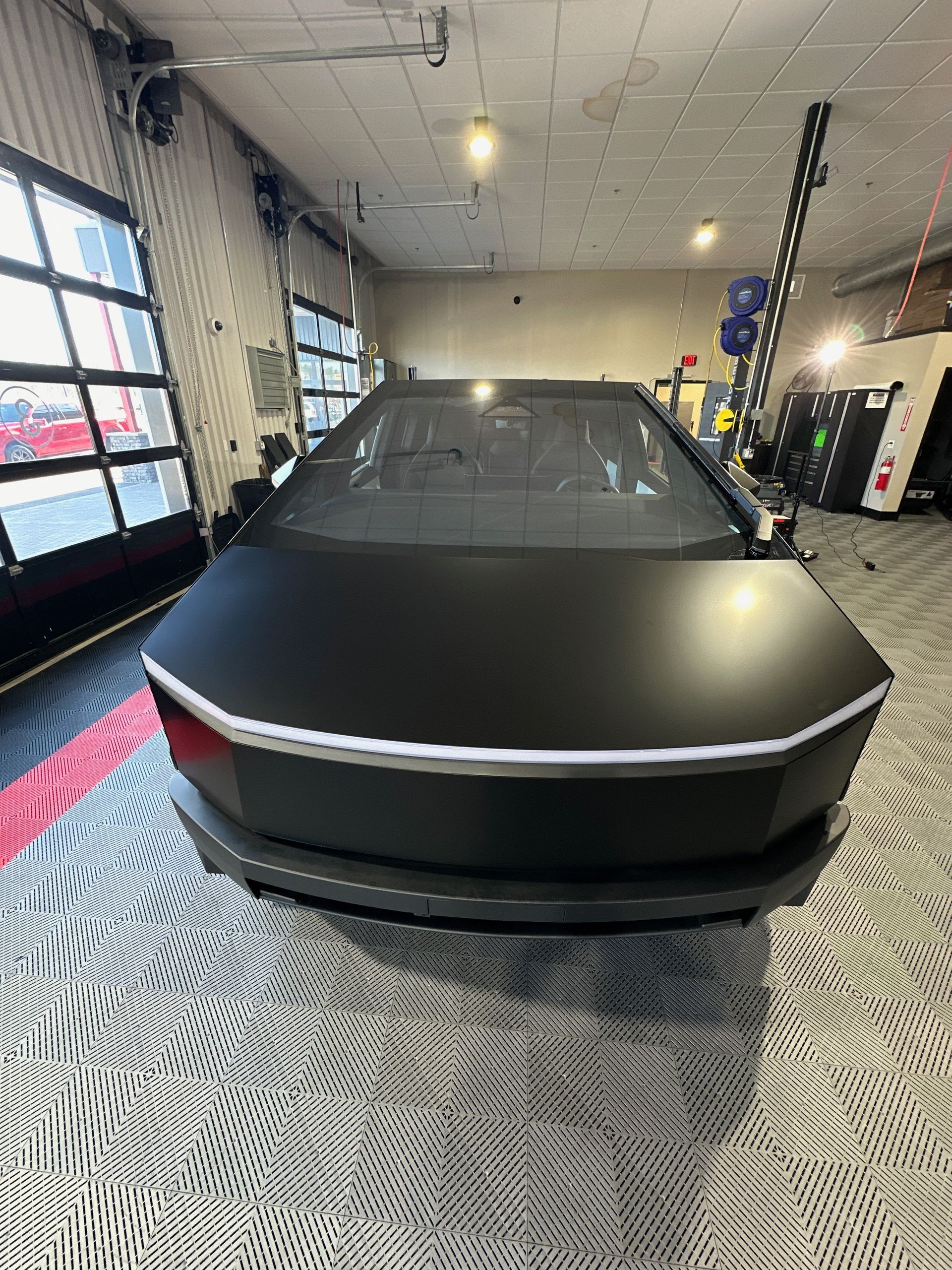 A black tesla model s is parked in a garage.