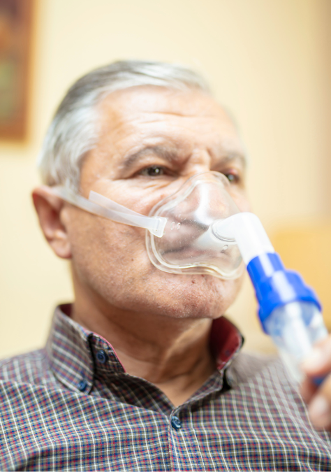 An elderly man is wearing an oxygen mask.