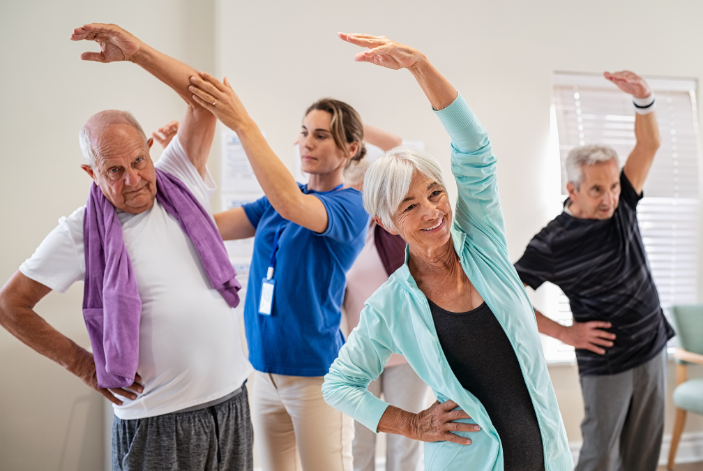 A group of elderly people are doing stretching exercises in a room.
