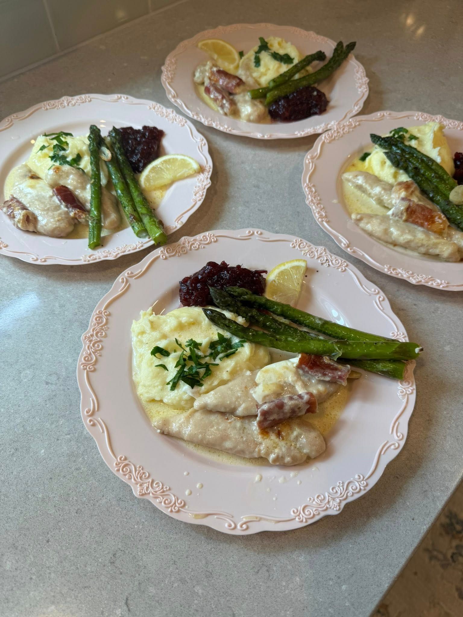 Three plates of food with mashed potatoes and asparagus on a table.