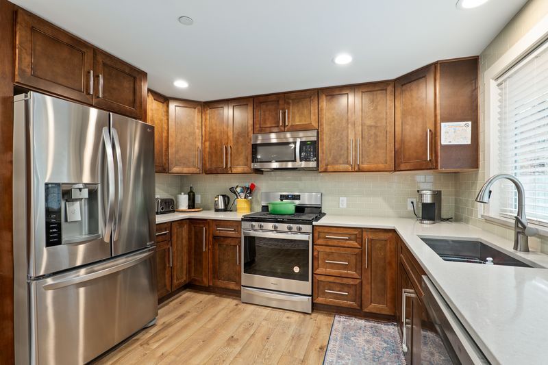 A kitchen with stainless steel appliances and wooden cabinets.