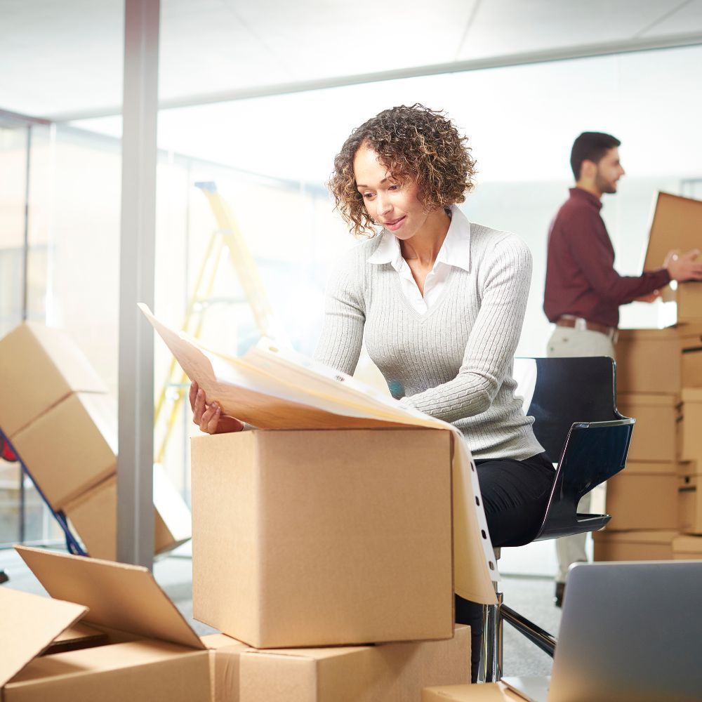 Office relocation in progress with staff and moving boxes
