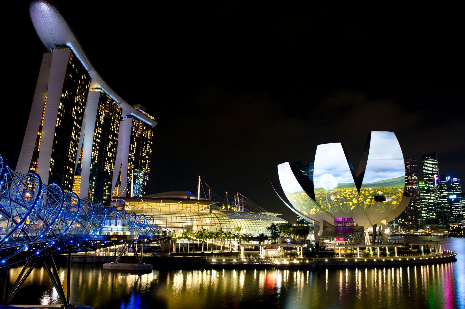 Night skyline view of Marina Bay Sands and the Singapore waterfront, a 5-star city destination ideal for premium First & Business Class Flight + Hotel packages - xLuxuryFlights.com