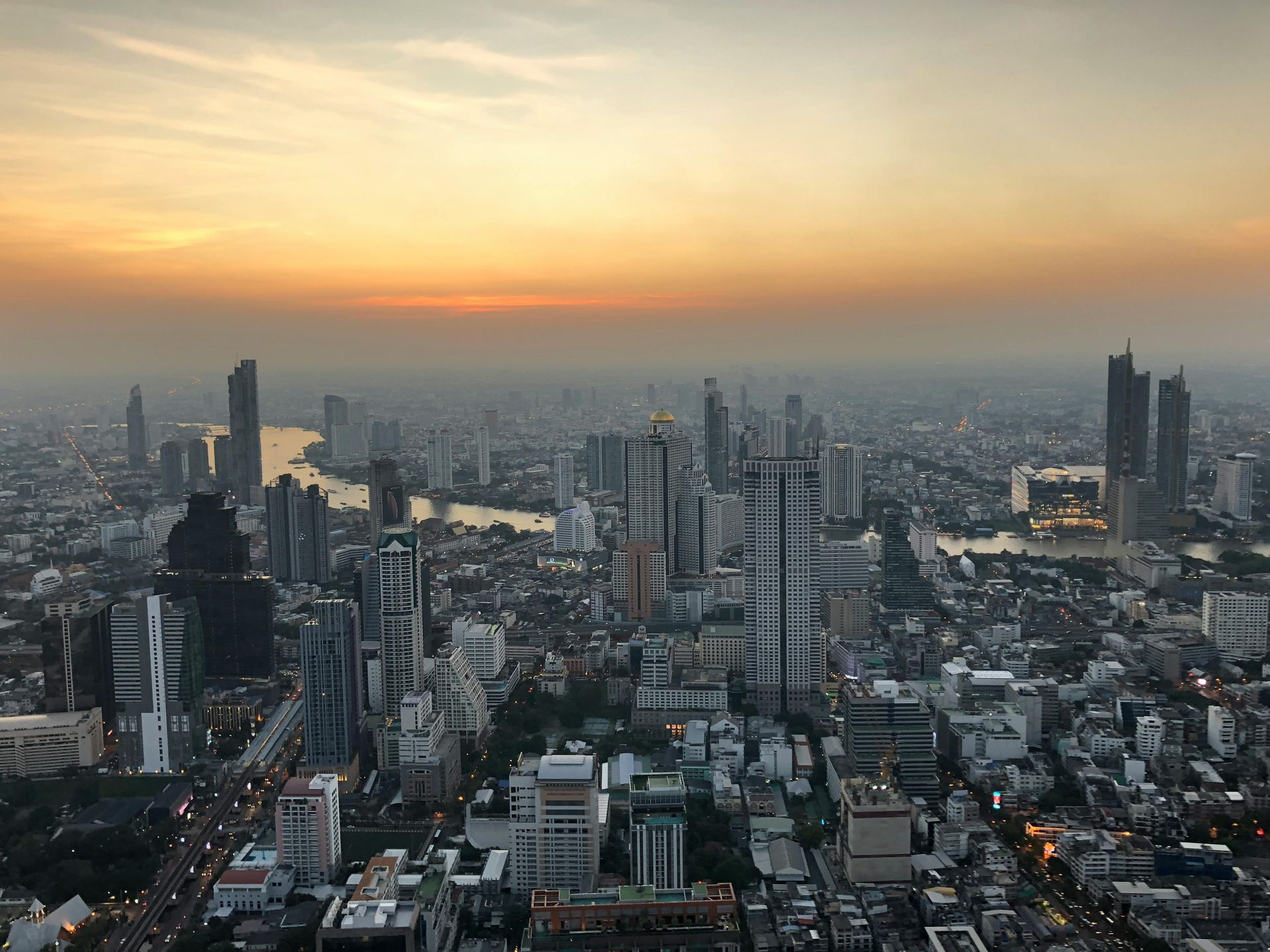 Sunset skyline view over central Bangkok with high-rise buildings, a 5-star city destination ideal for premium First & Business Class Flight + Hotel holidays - xLuxuryFlights.com