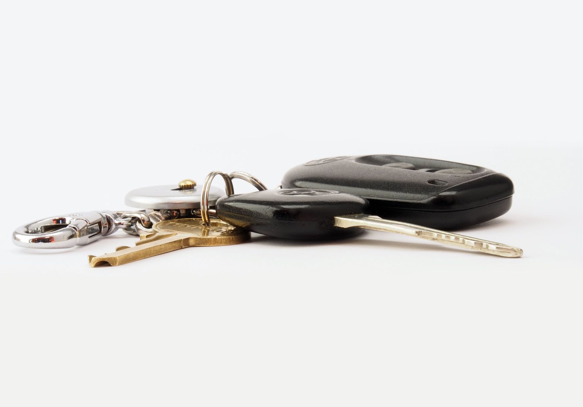 A set of car keys and a black key fob on a white background