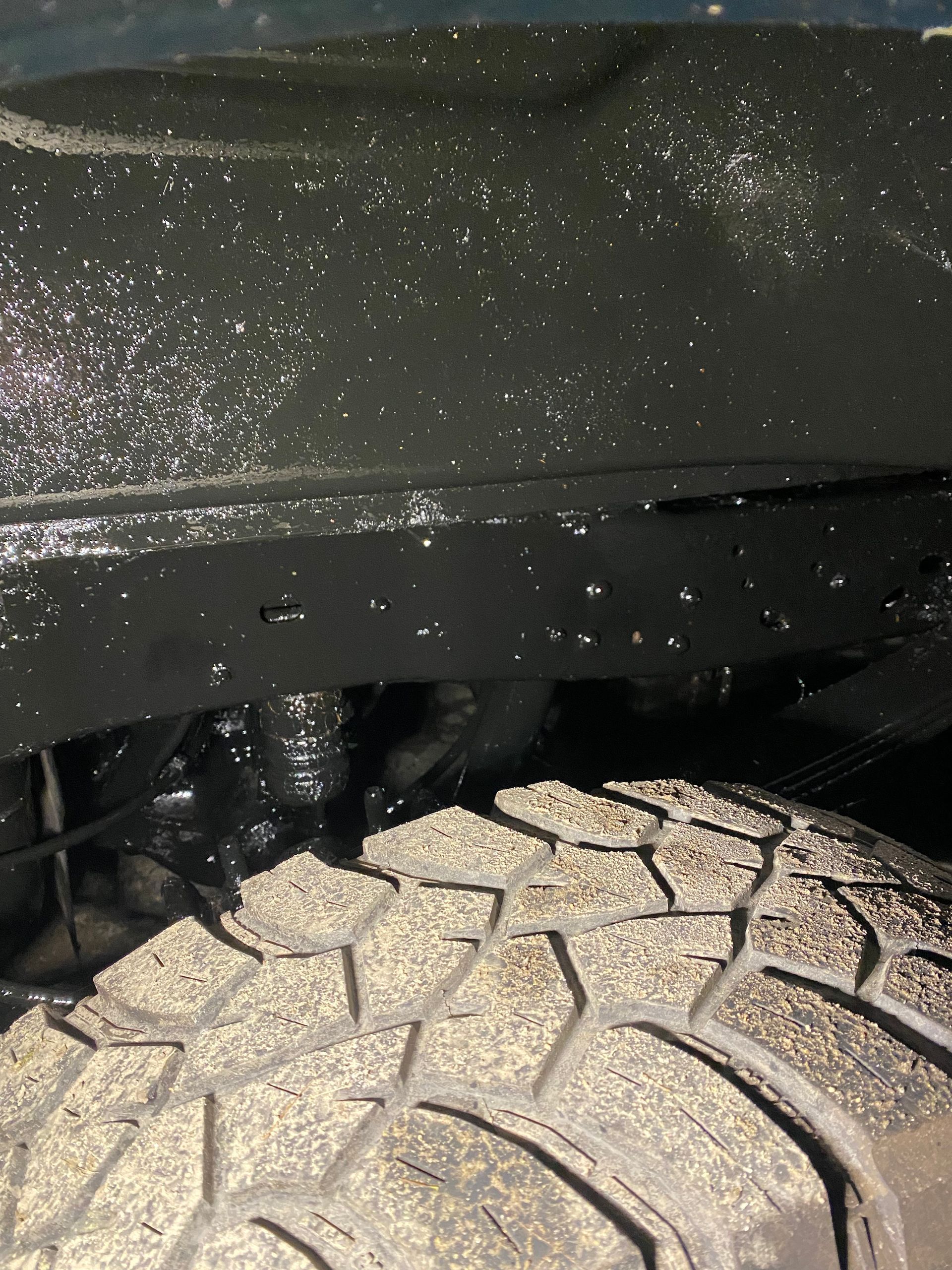A close up of a tire and fender of a car
