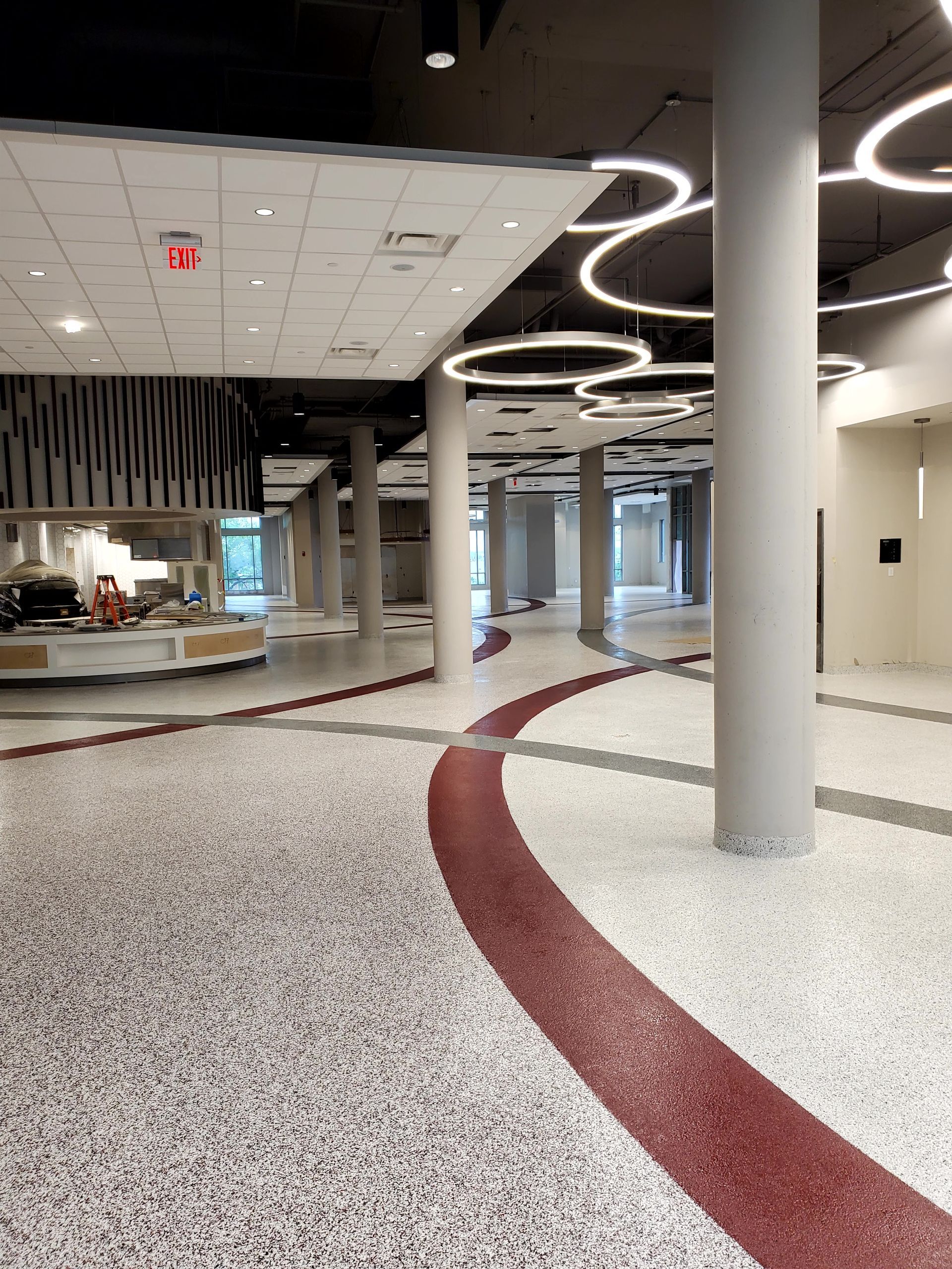 Close-up of a shiny, speckled epoxy floor in a room, reflecting overhead lights.