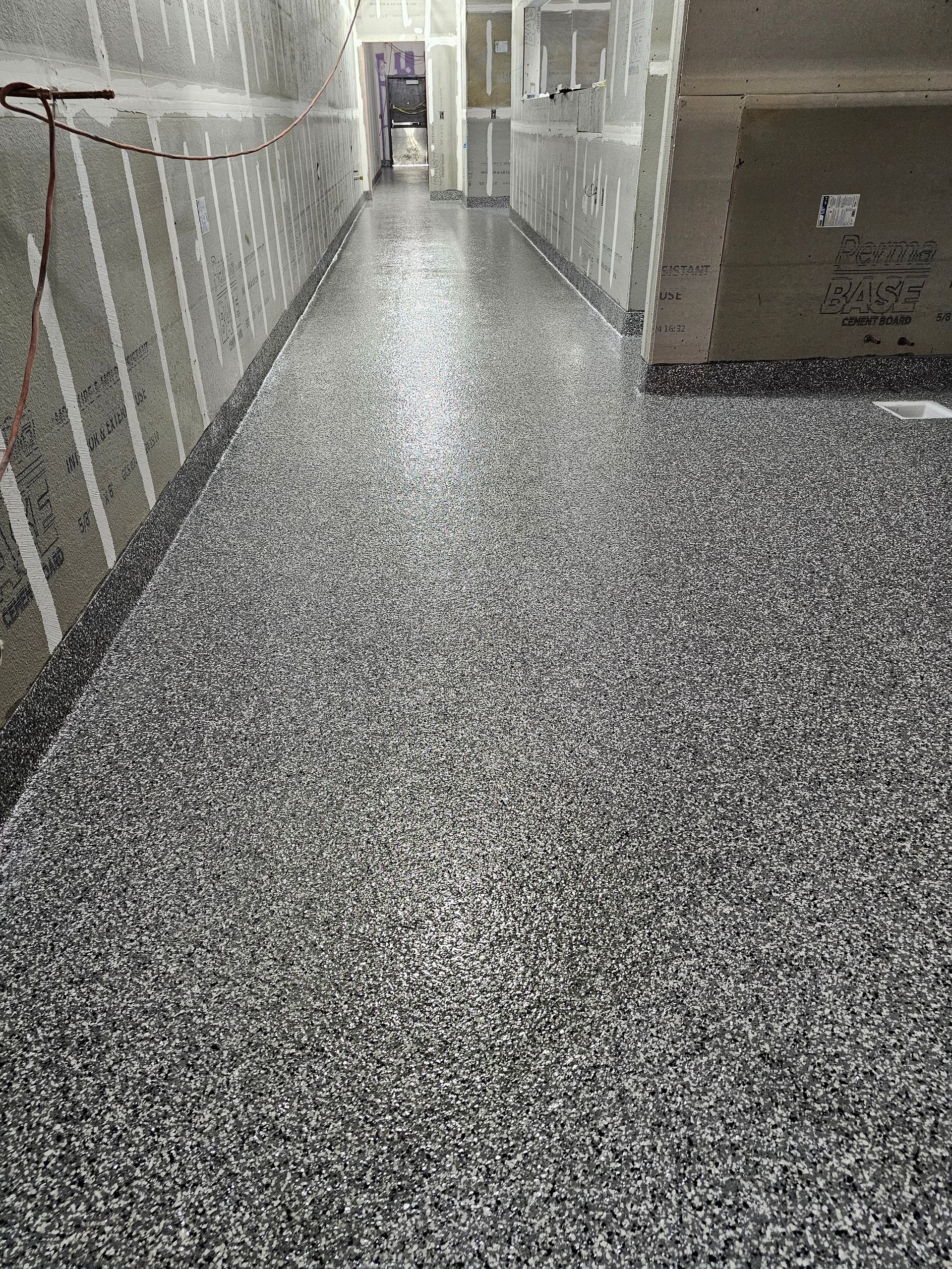 Wall display of various square and rectangular tiles in shades of gray, black, white, and brown.