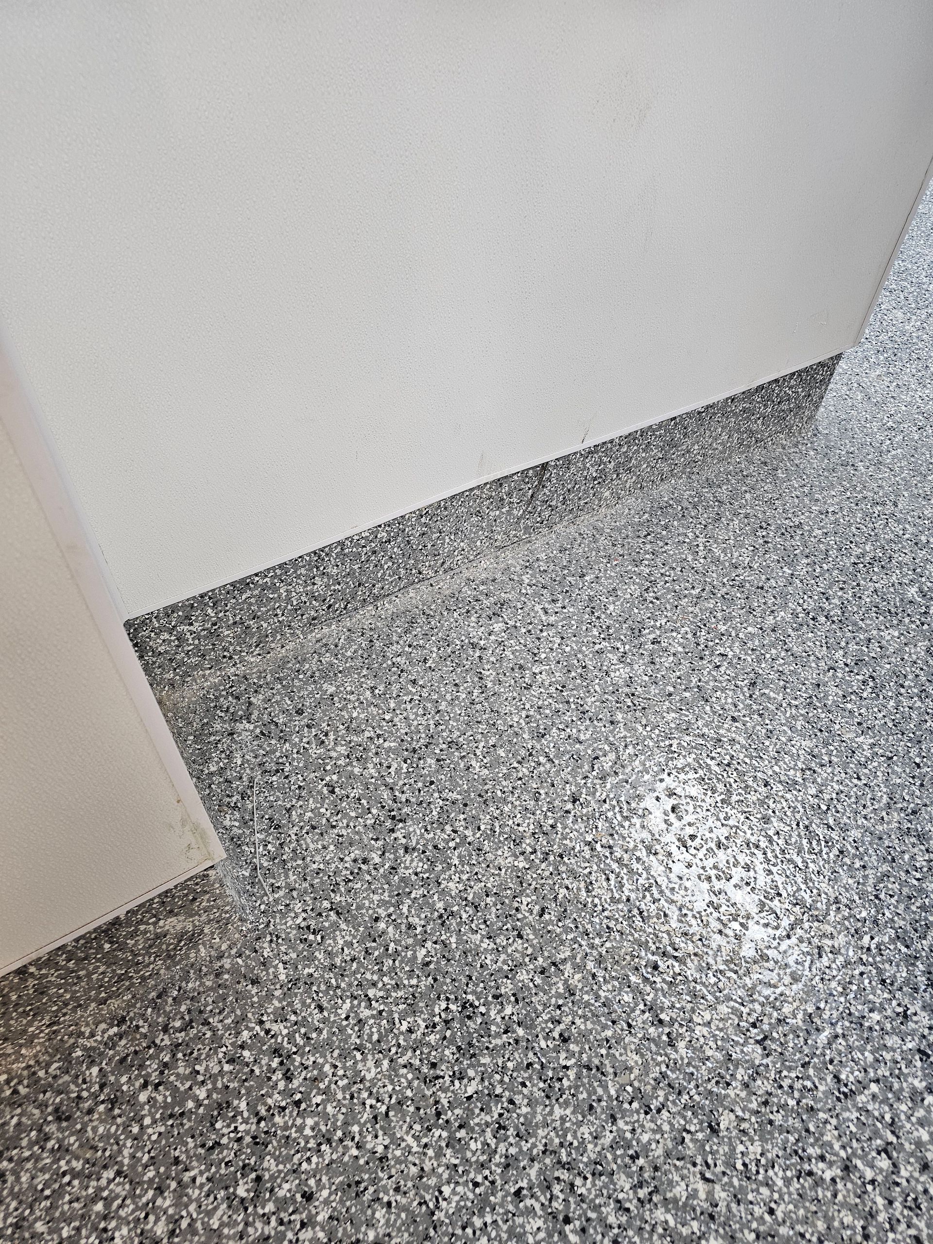 Wall display of various square and rectangular tiles in shades of gray, black, white, and brown.