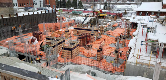 Un chantier de construction avec beaucoup de terre et des maisons en arrière-plan