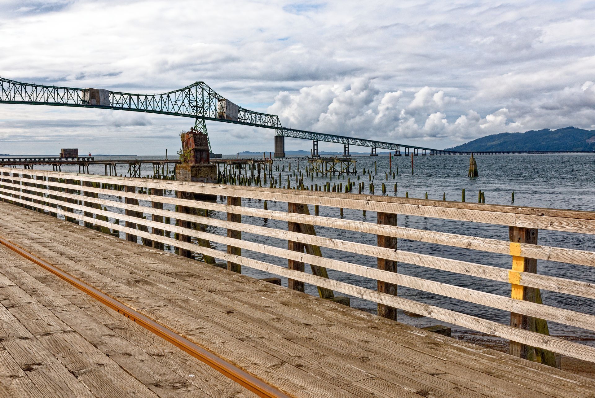 A bridge over a body of water with a wooden fence in the foreground