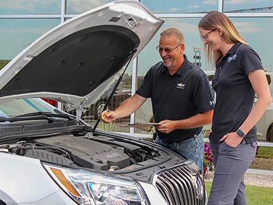 workers looking at car together