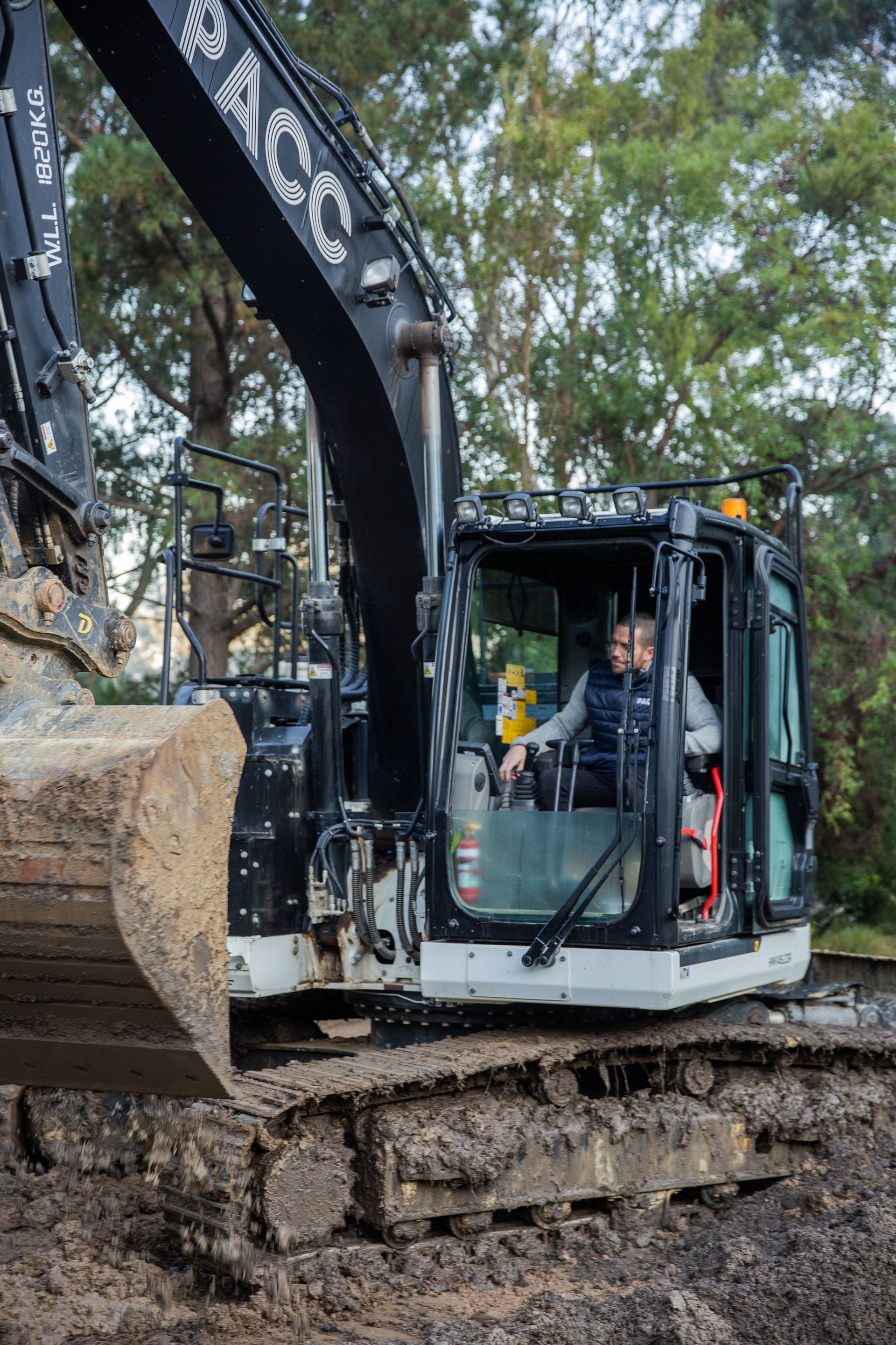 A man is sitting in the driver 's seat of an excavator.