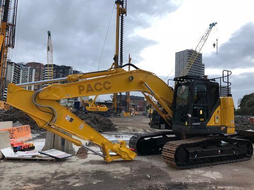 A large yellow excavator is parked on a construction site.