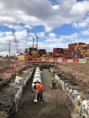 A man is working on a pipe in a construction site.