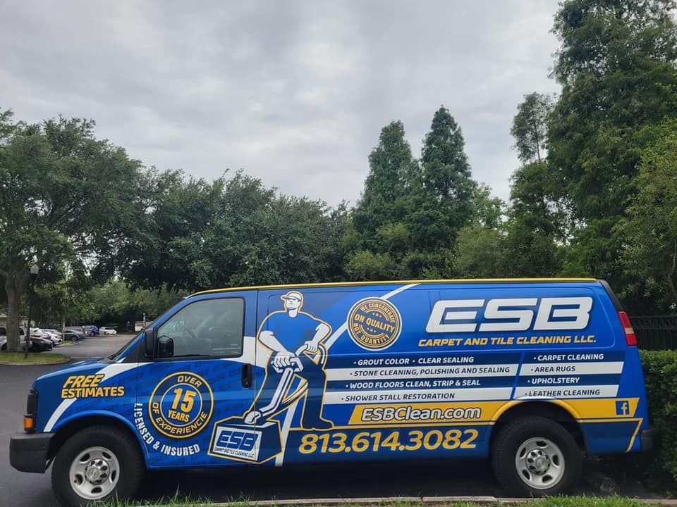 A blue and yellow esb van is parked in a parking lot