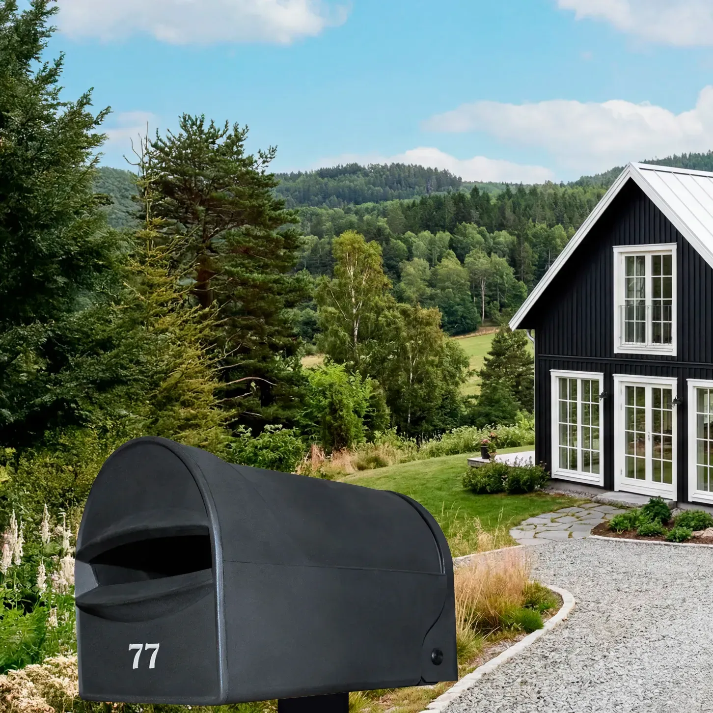 A green mailbox labeled 775 stands in front of a light green house with a covered porch, surrounded by trees and flowers.