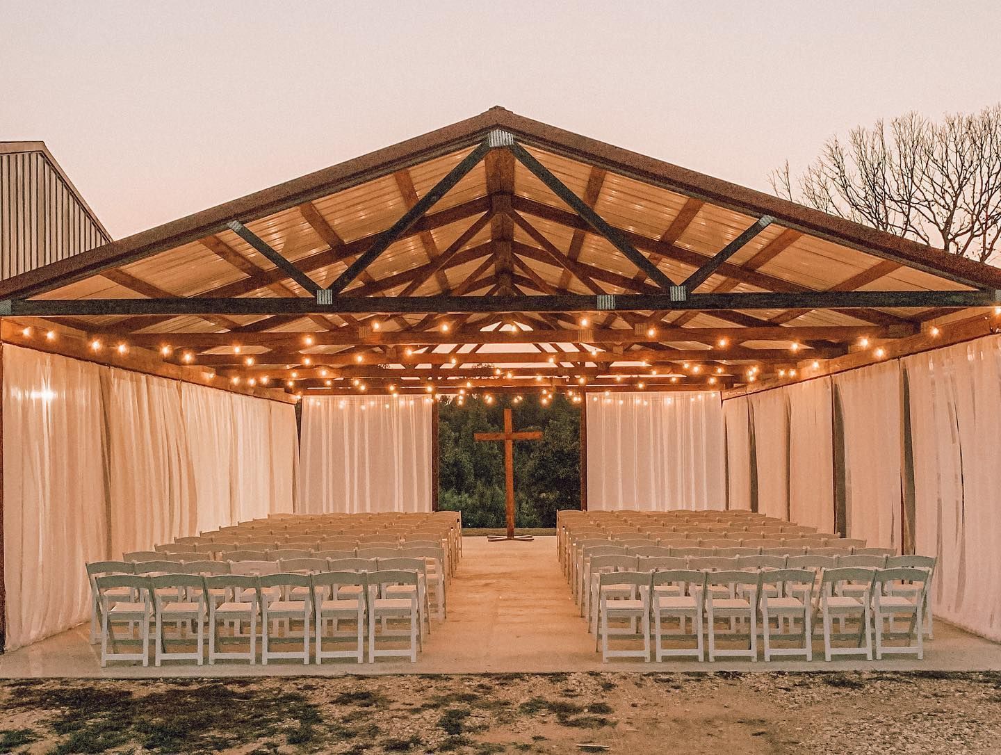 Rustic outdoor wedding pavilion with string lights and ceremony seating in Little Rock, AR
