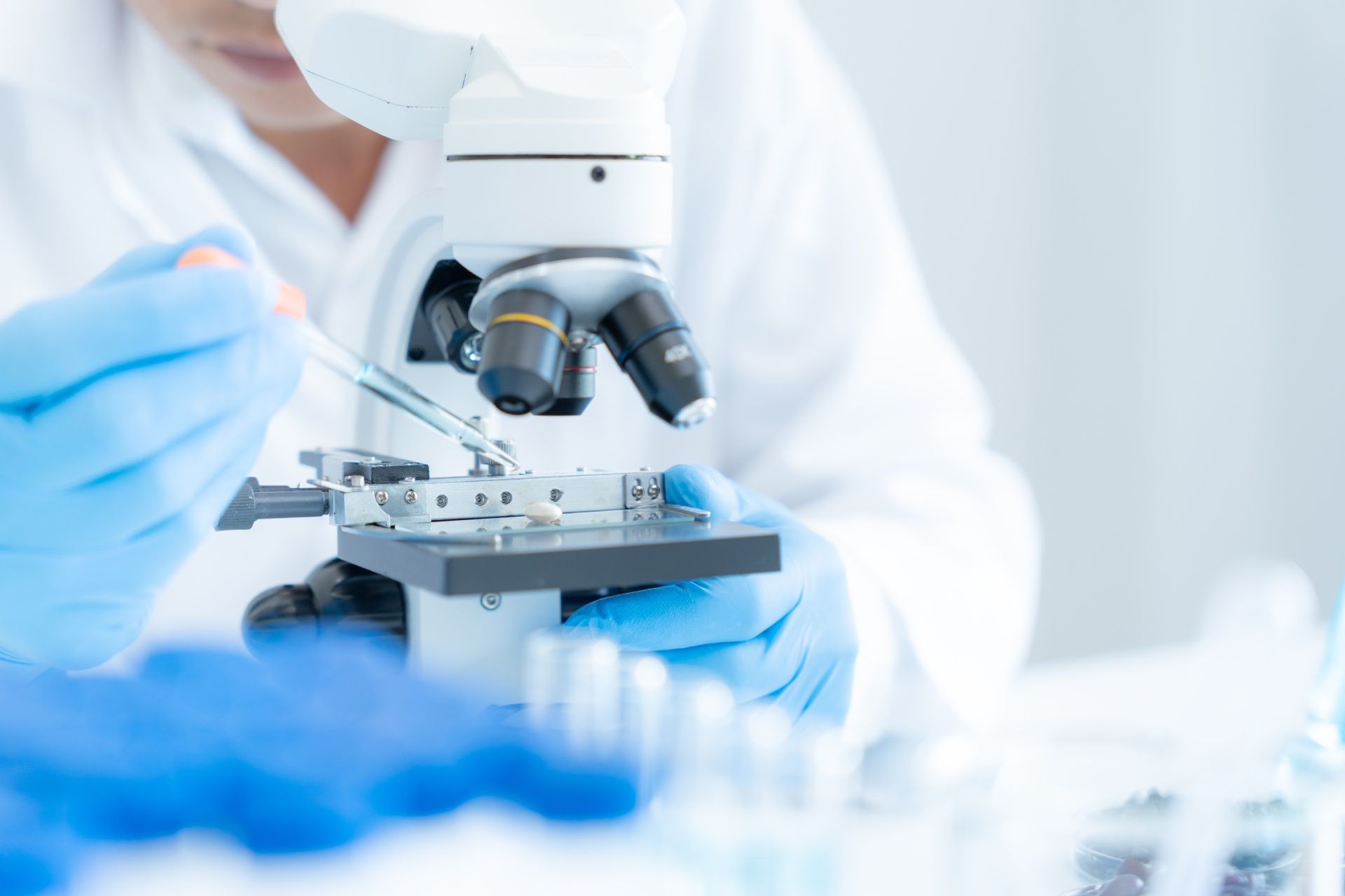 A scientist is looking through a microscope in a laboratory.