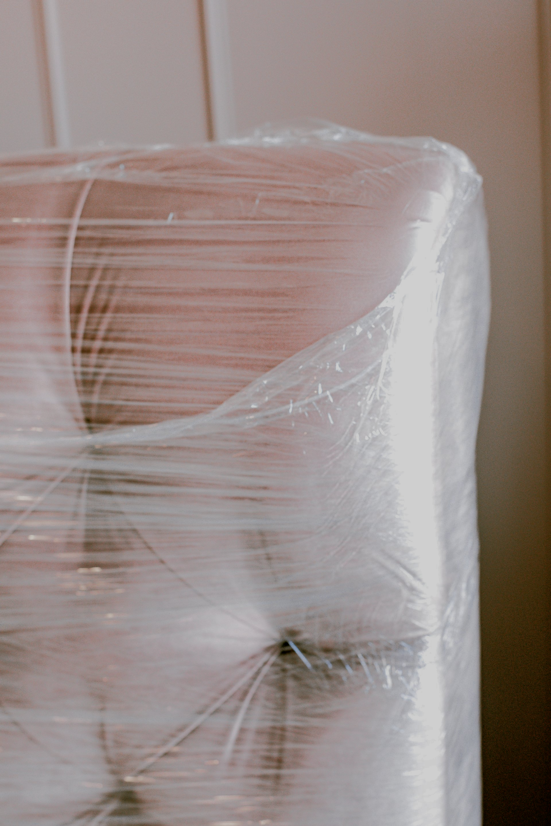 A piece of furniture is wrapped in plastic wrap.