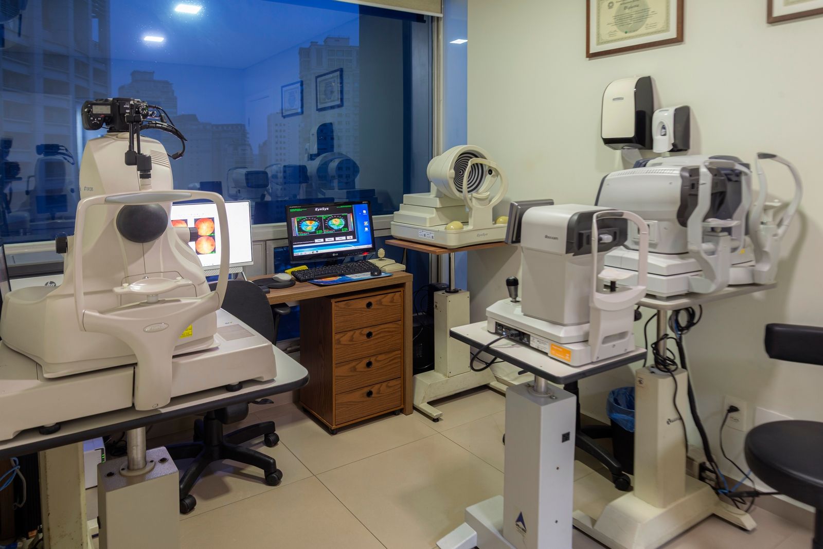 Uma sala de exames oftalmológicos com vários aparelhos de exame oftalmológico.