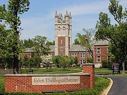 Eden Theological Seminary sign in front of brick building with a tower.