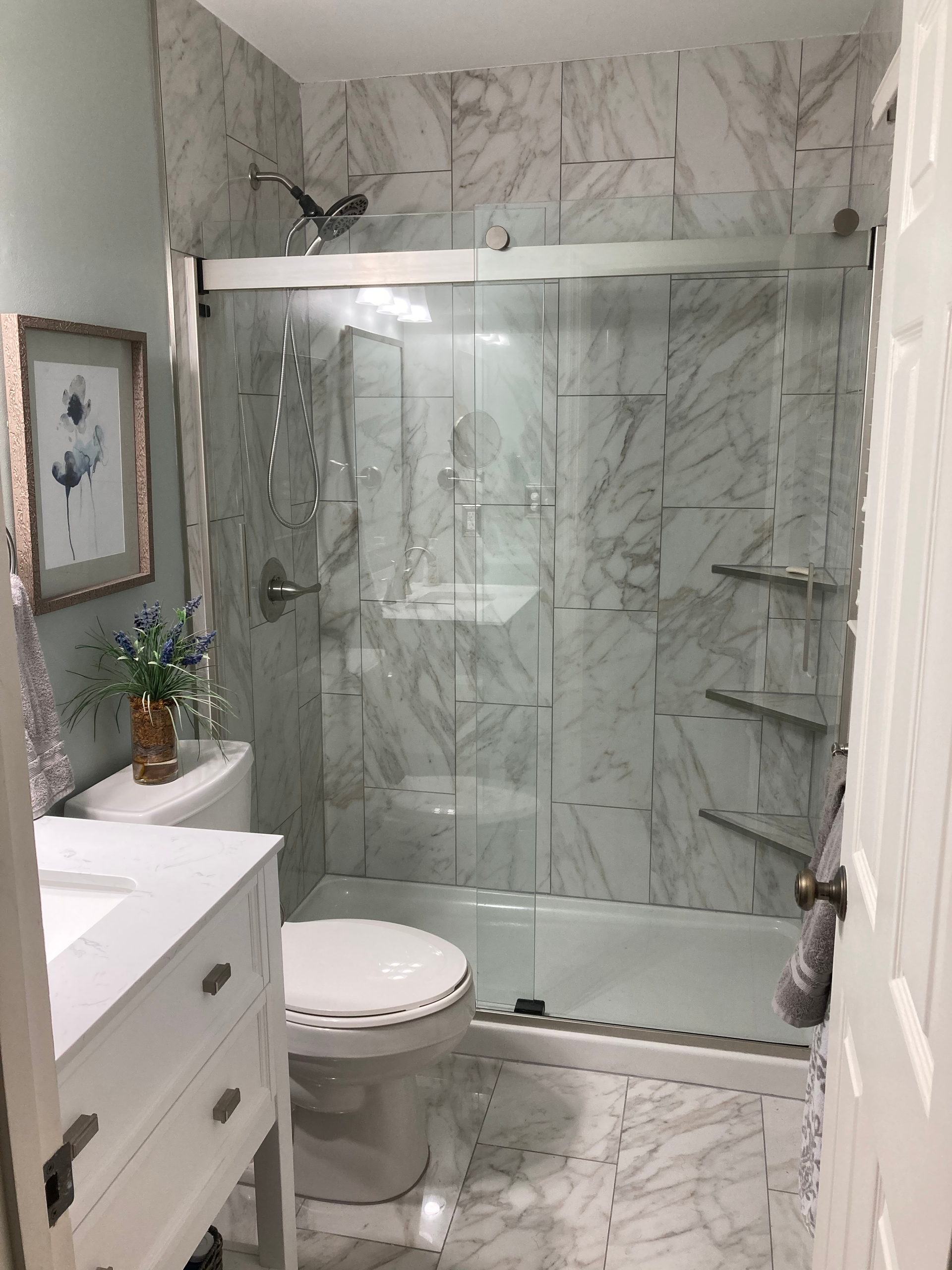 A bathroom with a toilet , sink and shower.