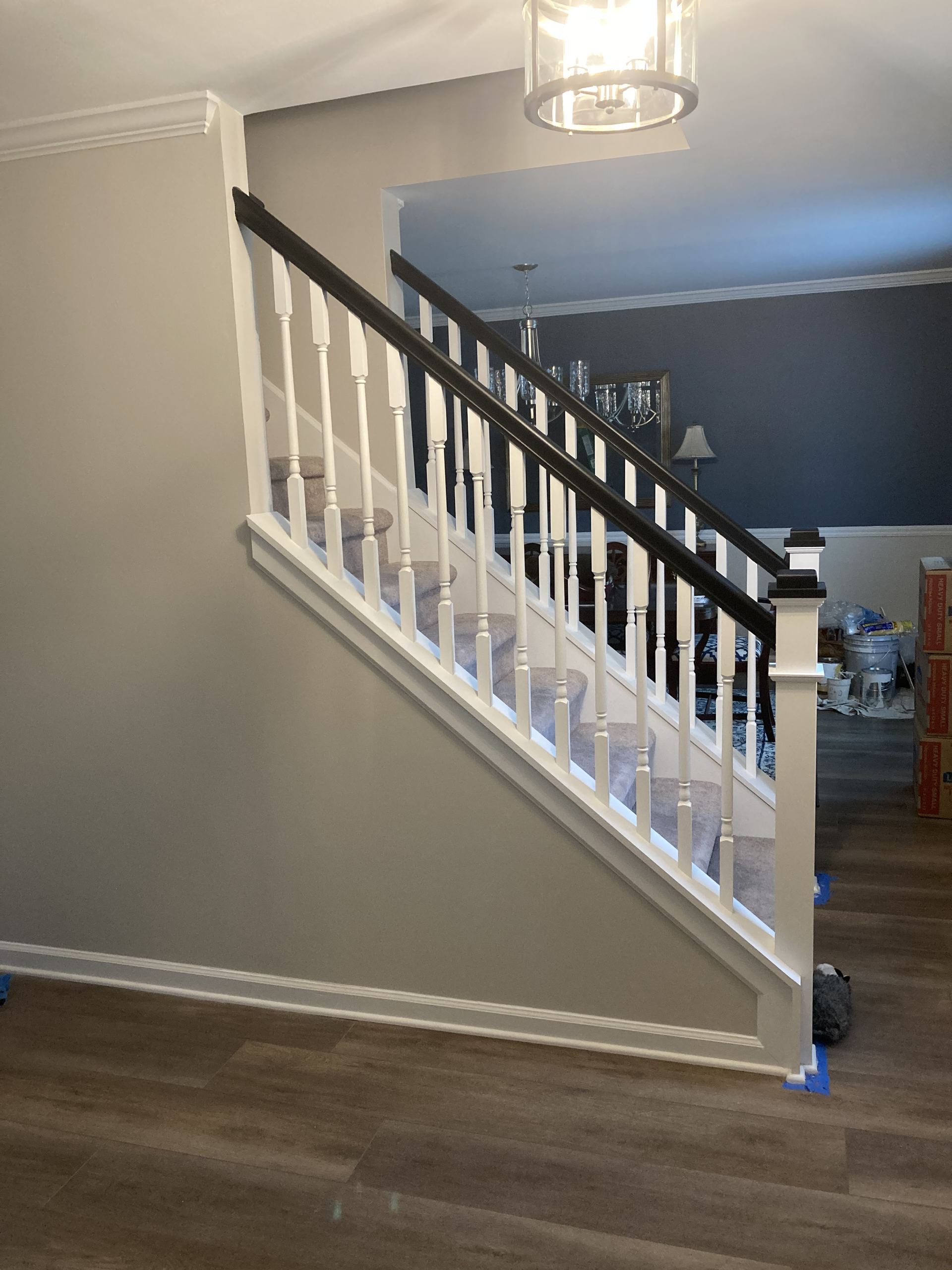 A white staircase with a black railing in a living room