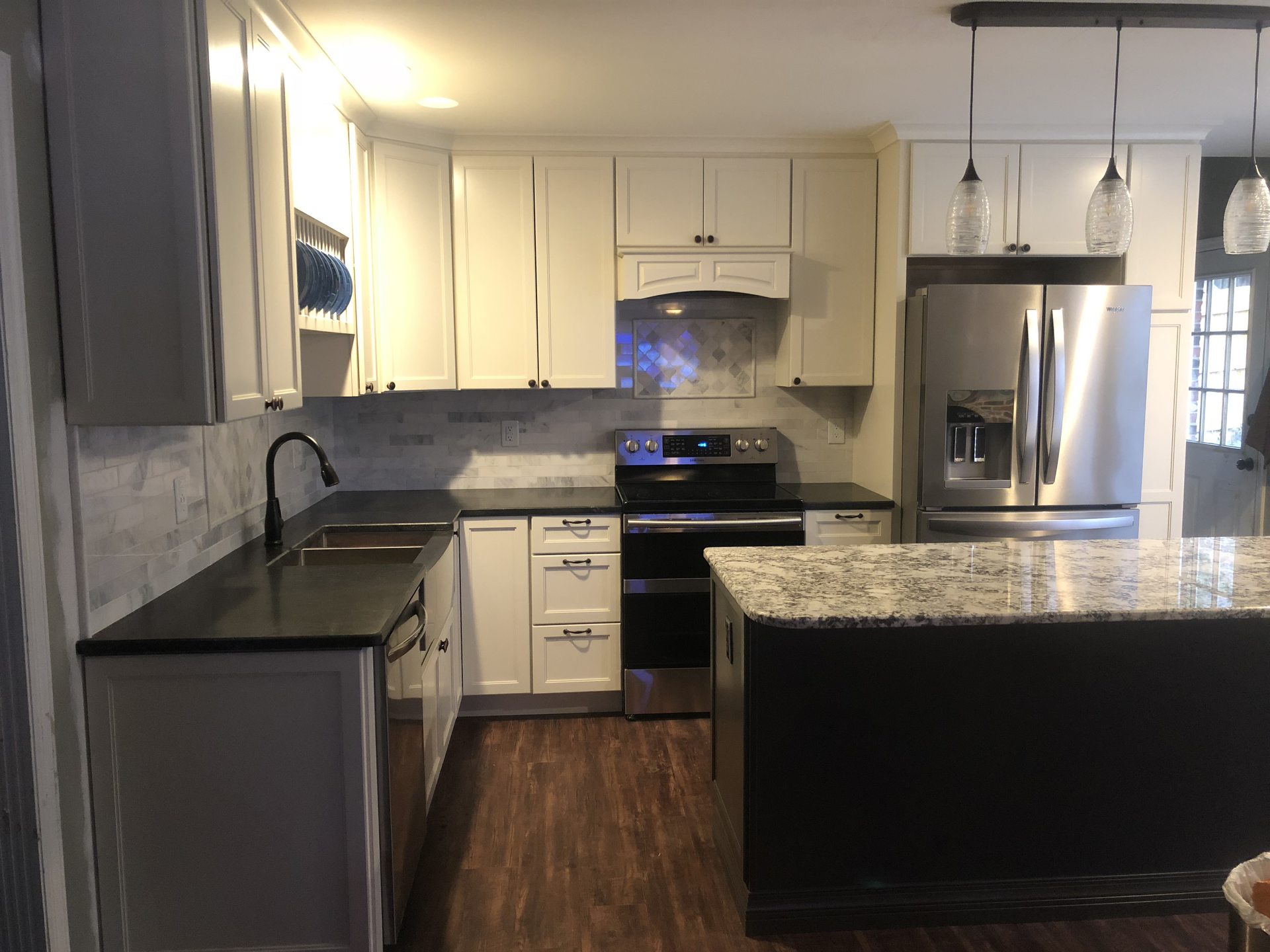 A kitchen with stainless steel appliances and granite counter tops.