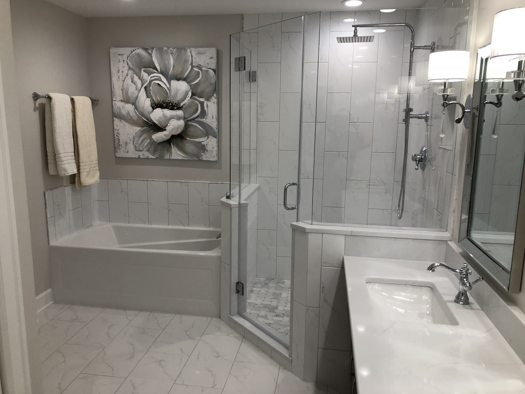 A bathroom with a tub , sink , mirror and shower.