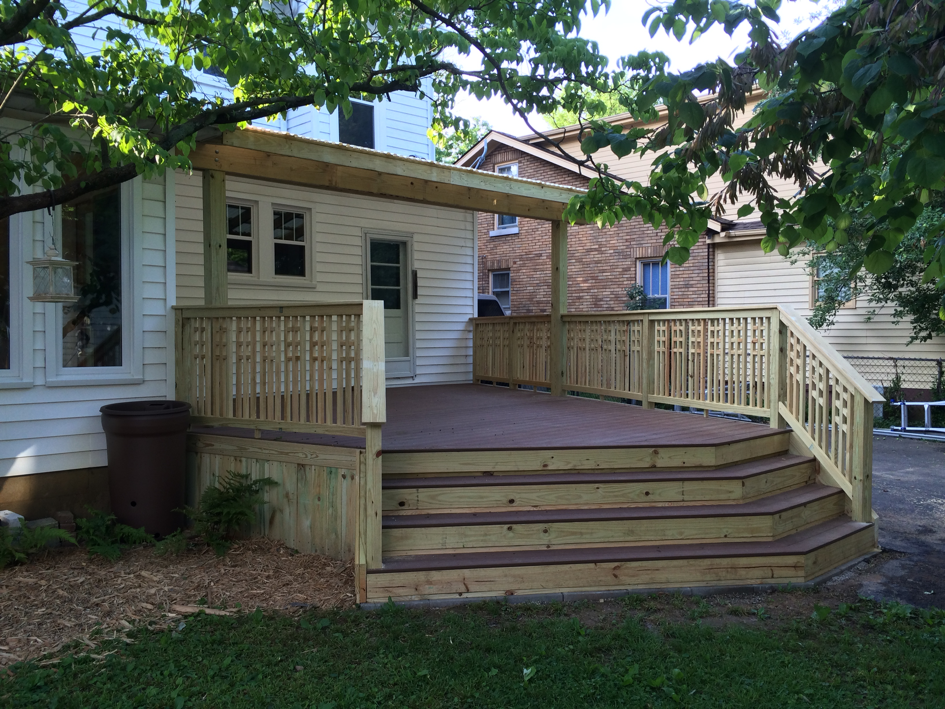 A white house with a wooden deck in front of it