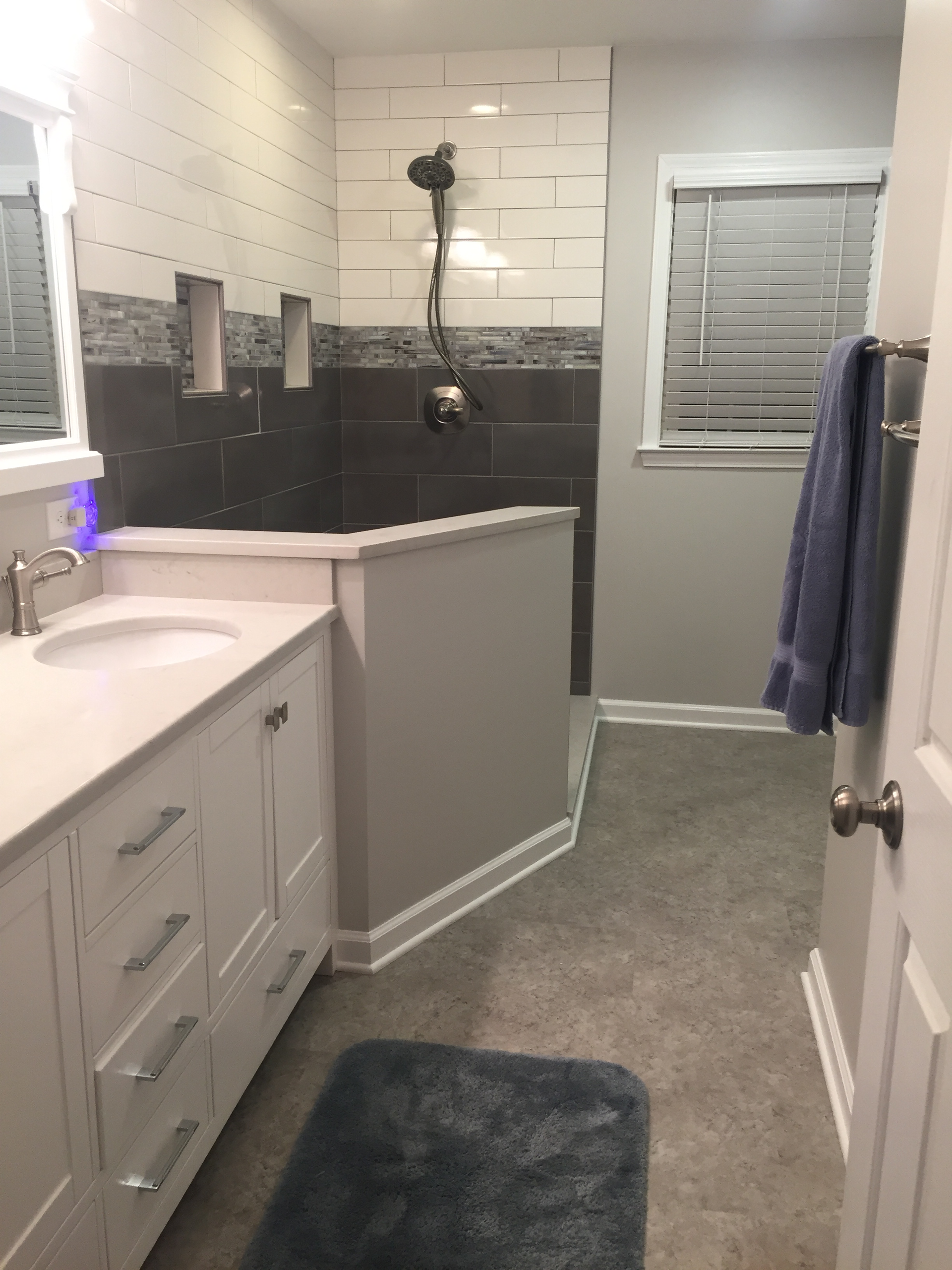 A bathroom with a sink , mirror , and shower.