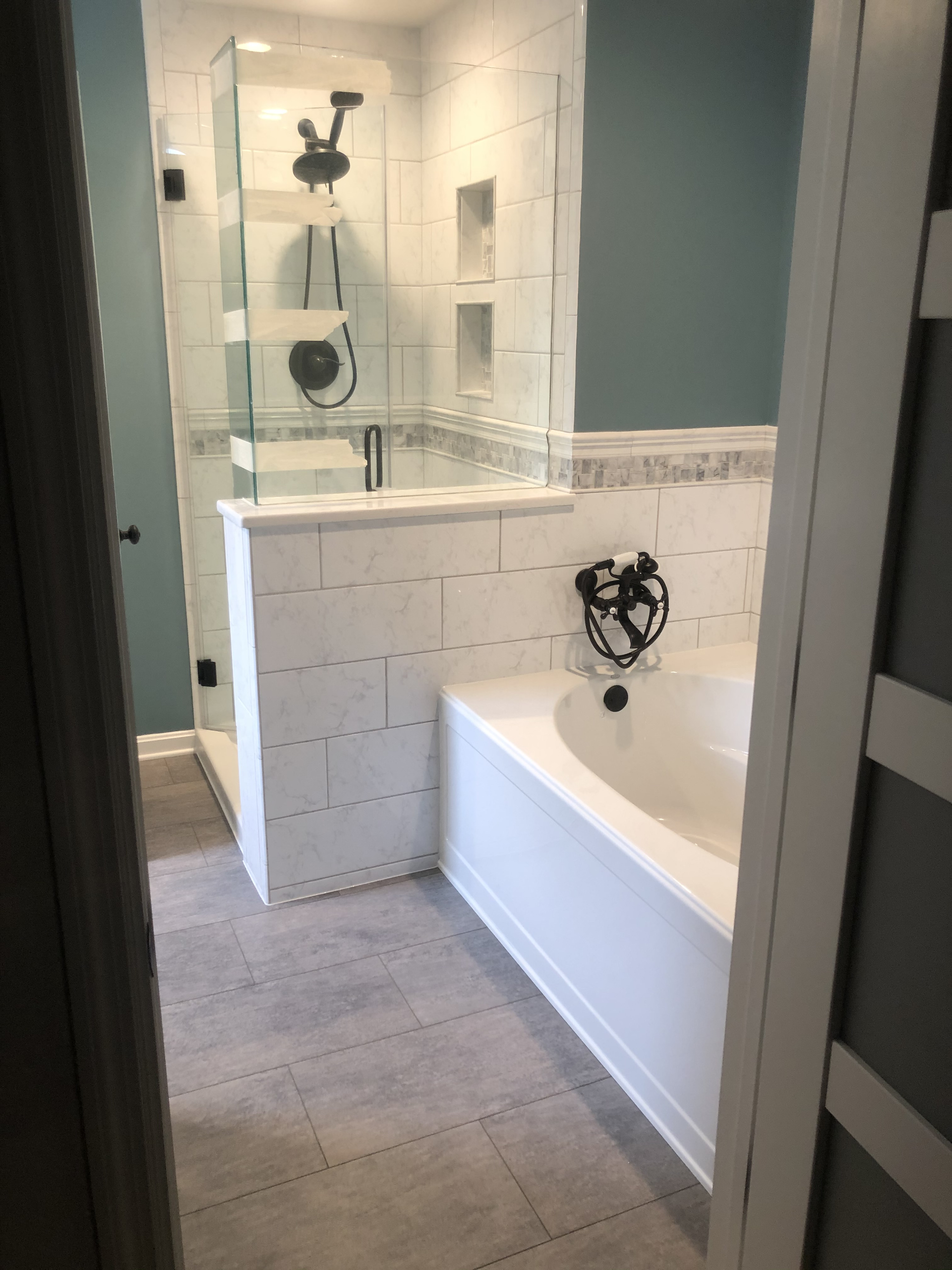 A bathroom with a tub , shower , and walk in shower.