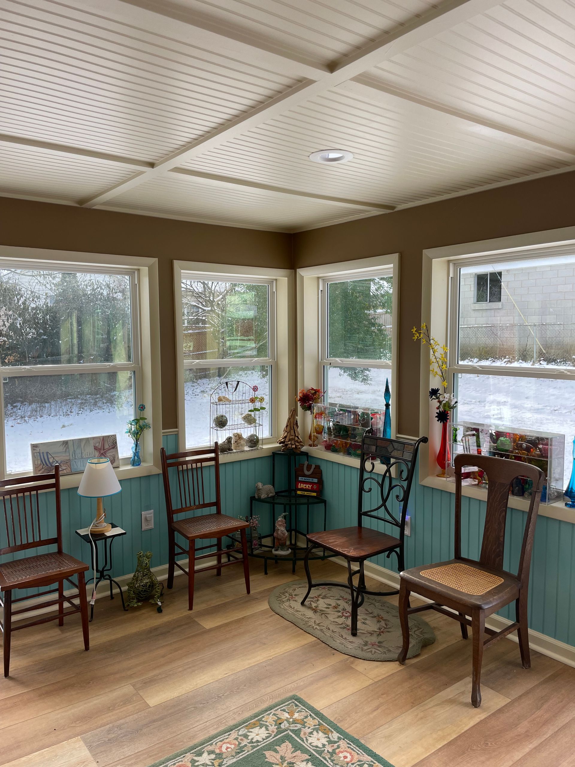 A living room with a lot of windows and chairs