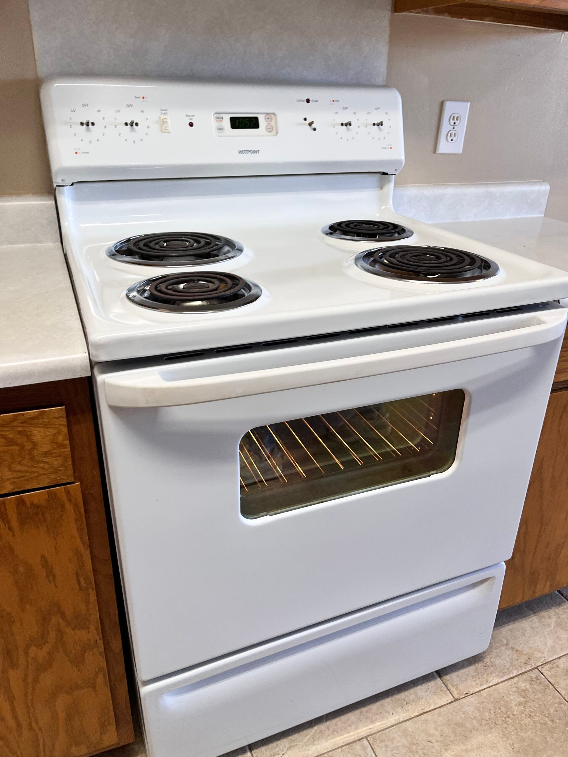 White electric range with four burners, oven, and storage drawer.