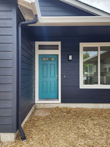 A blue house with a blue door and a white window.
