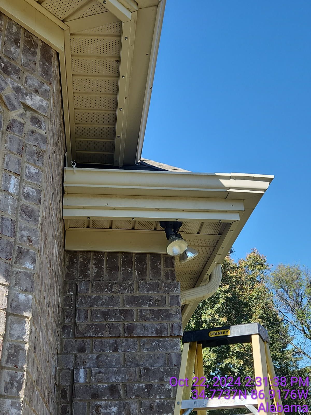 Brick house exterior with a security light mounted under the eaves.