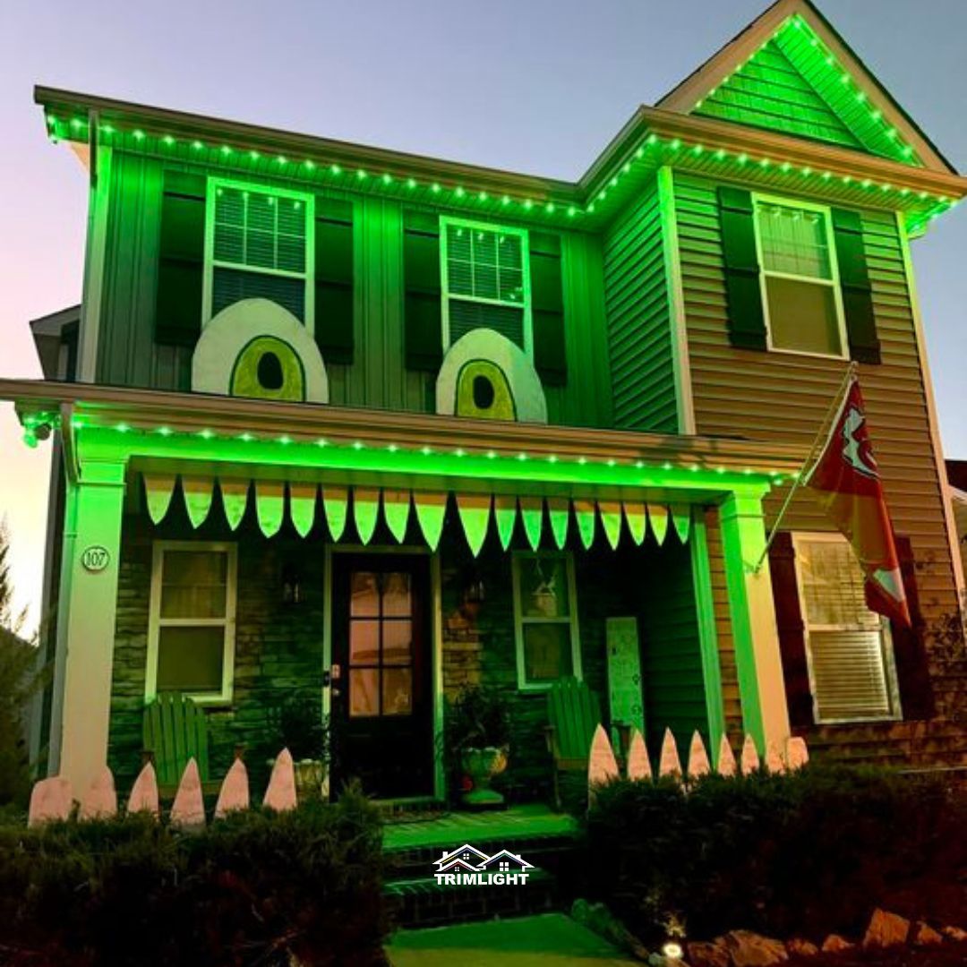 House decorated for Halloween with giant eyes, green lights, and tooth-like porch trim.