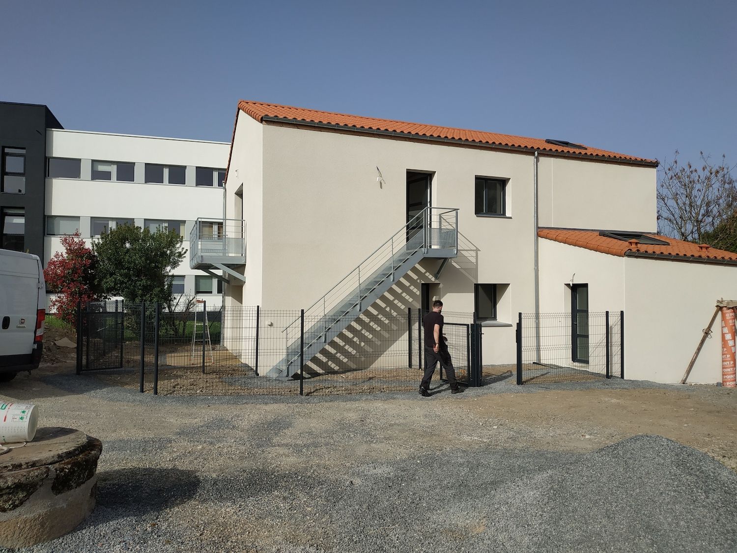 Une maison blanche avec des chaises jaunes devant