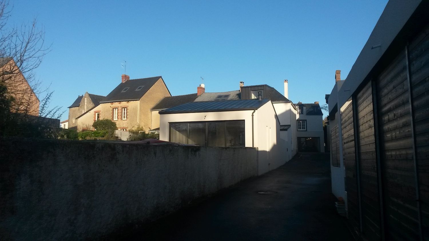 Une maison blanche avec des chaises jaunes devant