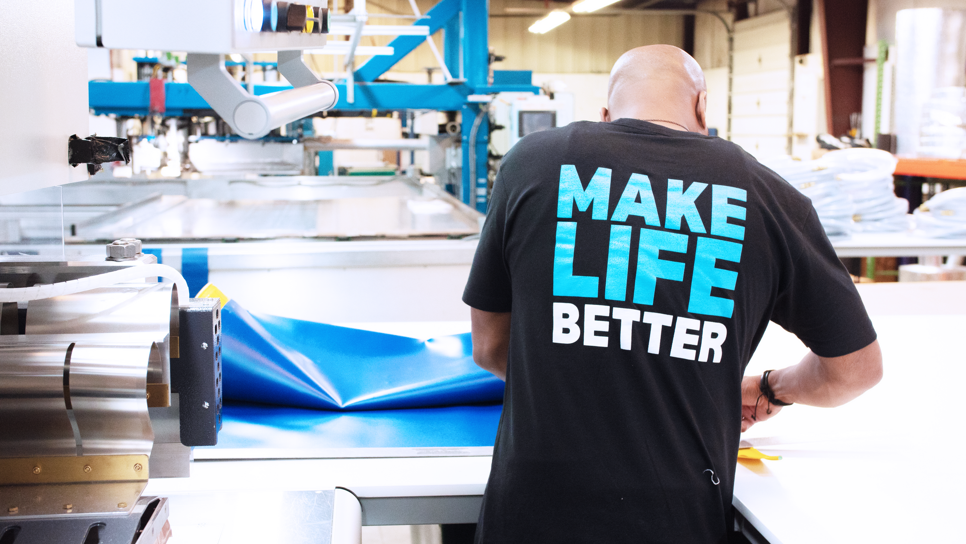 A man wearing a black shirt that says make life better