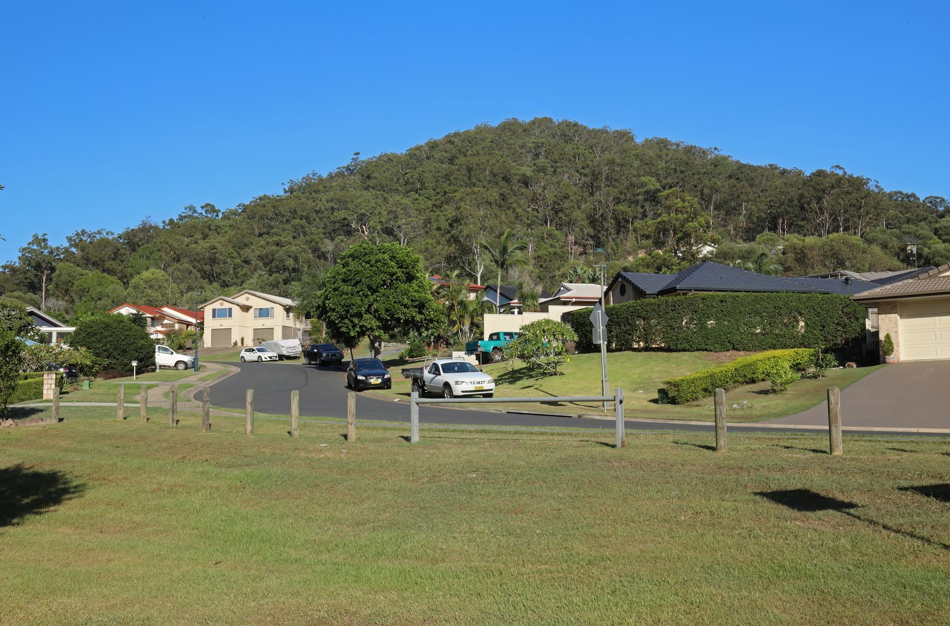 Residential Street With Houses and a Wooded Hill — Rob's Rubbish Removal in Logan, QLD